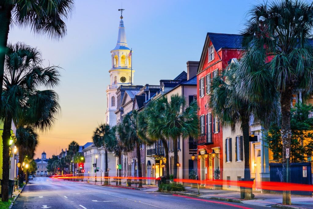 An image showing one of the main streets in Charleston, South Carolina. It shows several colorful buildings and a large church