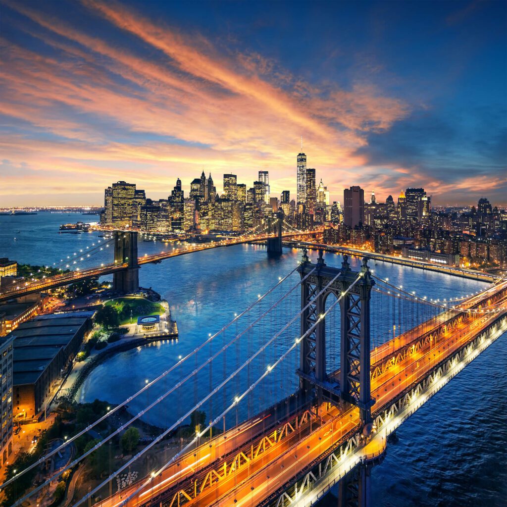 An aerial view of Manhattan. Lots of city lights and bridges. City skyline at dusk.