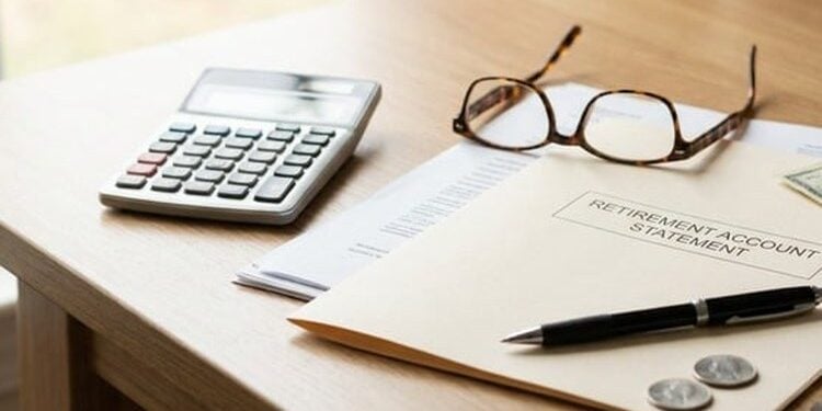 Calculator, retirement paperwork, and cash on a desk for required minimum distributions guide
